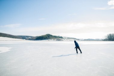 Kış aylarında buz pateniyle buz hokeyi sopası ile gölde son sınıf öğrencisi. Yaşlıların hobi anlayışı.