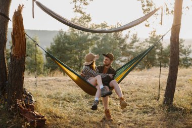Mutlu çift, dışarıda gün batımının tadını çıkarırken hamakta dinleniyor..