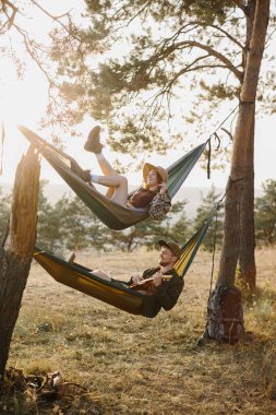 Bir erkek ve bir kız gün batımında bir çam ormanında hamaklarda dinleniyorlar. Dağlarda yürüyüş yaptıktan sonra hamaklarda dinlenen bir çift, ukulele çalan bir adam..