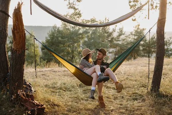 Mutlu çift, dışarıda gün batımının tadını çıkarırken hamakta dinleniyor..