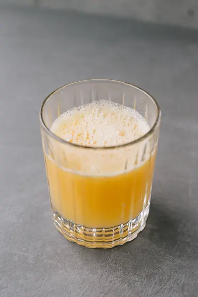 灰色の石の背景にオレンジジュースのグラスを閉じる — ストック写真