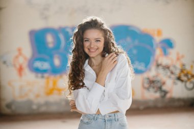 Grafiti arka planında poz veren güzel genç bir kadın..