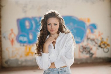 Grafiti arka planında poz veren güzel genç bir kadın..