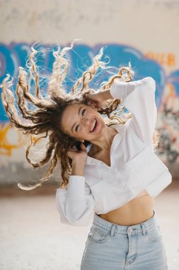 Grafiti duvarlarına karşı poz veren güzel bir genç kadının sokak tarzı portresi..