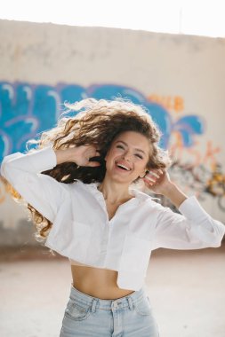 Grafiti duvarlarına karşı poz veren güzel bir genç kadının sokak tarzı portresi..