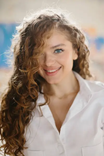 Grafiti arka planına karşı sokakta poz veren hoş, genç bir kadın..