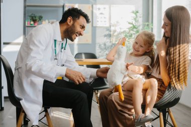 Annesiyle birlikte küçük tatlı bir kız hastanede bir çocuk doktoru tarafından muayene ediliyor..