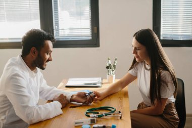 Aile doktoruyla randevusu olan genç bir kadın..
