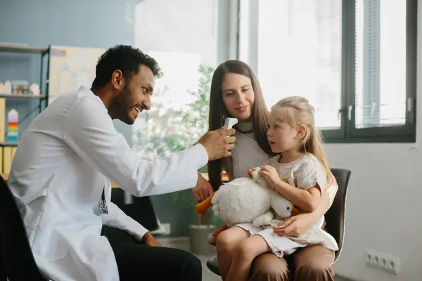 Młody Pediatra Sprawdza Temperaturę Małego Pacjenta Matka Córka Wizycie Lekarza — Zdjęcie stockowe
