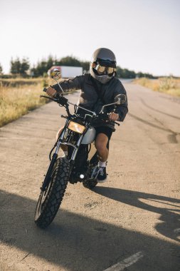 Gün batımında bir kafede motosikletli bir motorsikletli..