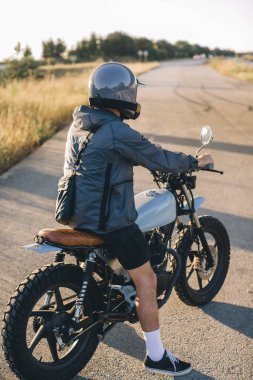 Gün batımında asfalt yolda motosiklet sürüyorum..