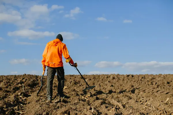 A man with an electronic metal detector in the field. Copyspace