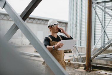 Bir mühendis tahıl ambarlarının yapımını denetliyor..