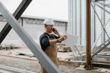 Bir mühendis tahıl ambarlarının yapımını denetliyor..