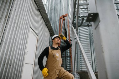 Bir mühendis tahıl ambarlarının yapımını denetliyor..