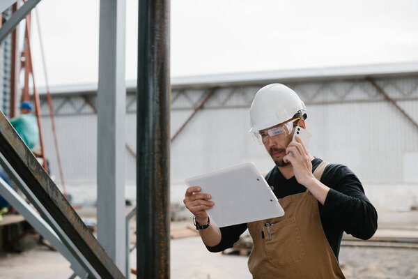 An engineer inspects the construction of grain storage silos.