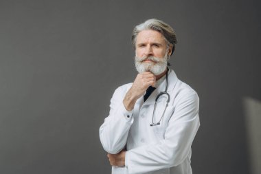 Gri arkaplanda falandoskopu olan beyaz bir doktor..