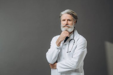 Gri arkaplanda falandoskopu olan beyaz bir doktor..