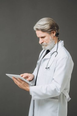Elinde tabletle kıdemli bir doktor. Sağlık ve Tıp Konsepti.