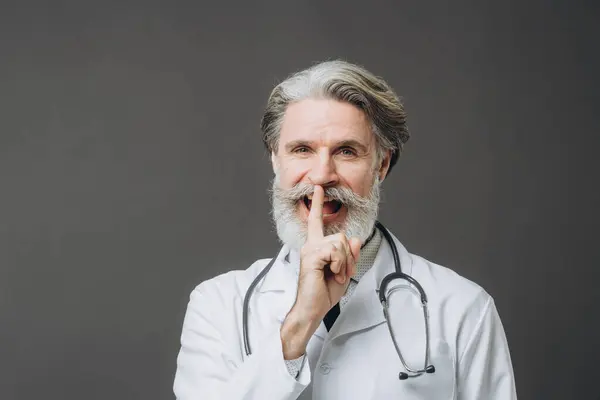 Šedovlasý Mužský Lékař Bílém Lékařském Kabátě Izolovaný Šedém Pozadí Zvedání — Stock fotografie