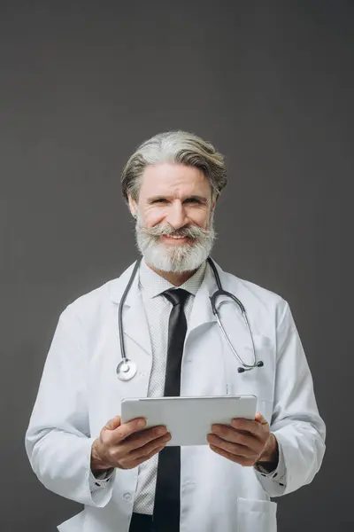 Šedovlasý Pohledný Mužský Lékař Tabulkou Ruce Šedém Pozadí — Stock fotografie