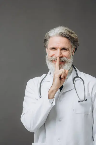 Grauhaariger Arzt Weißem Arztkittel Isoliert Auf Grauem Hintergrund Der Mit lizenzfreie Stockbilder