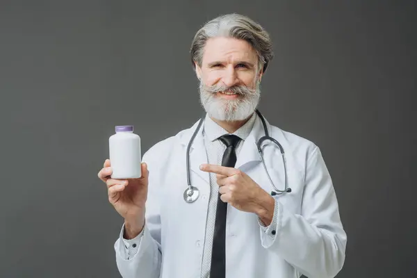 Médico Cabelos Grisalhos Com Casaco Branco Mostra Uma Garrafa Comprimidos Fotos De Bancos De Imagens