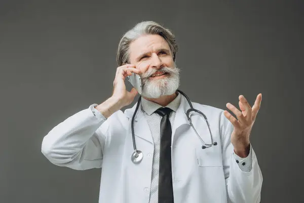Mand Læge Taler Telefon Isoleret Grå Baggrund Stock-foto