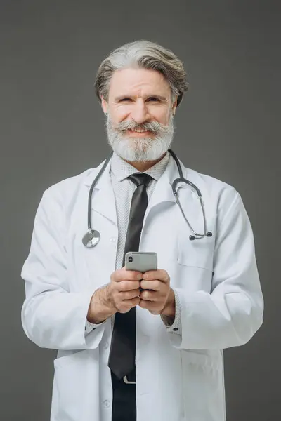 Portrait Middle Aged Male Doctor Phone His Hands Gray Background Stock Image