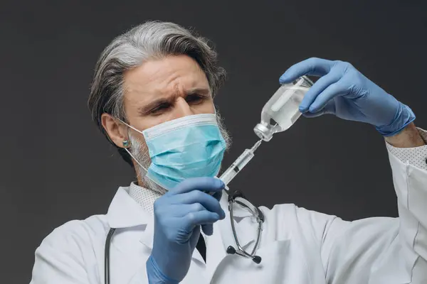Medico Anziano Maschera Protettiva Guanti Sta Preparando Iniezione Aspira Vaccino Foto Stock