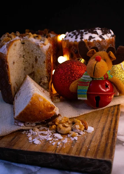 Karanlık bir arka planda meyve ve fındıklı noel pastası. Şenlik havası.