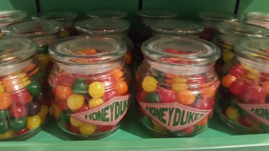 Farklı çeşitler, tatlar ve renklerle dolu cam kavanozlar.