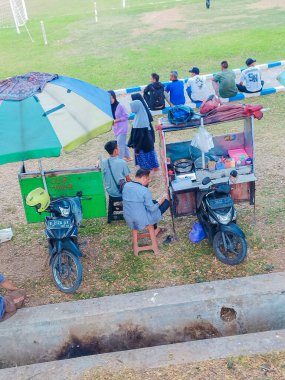 Yogyakarta, Endonezya - 1 Ağustos 2024: futbol sahasının kenarında yiyecek ve içecek satıcıları açık hava yiyecek ve içecekleri satıyor.