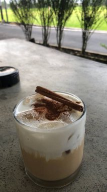 Dondurmalı bir fincan kahve ve masada bir fincan kahve.