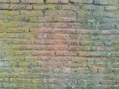 The texture of a very old vintage brick wall with residual elements of plaster decoration. clipart