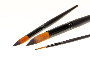Yatay konumda beyaz arkaplanda üç sanat fırçası.