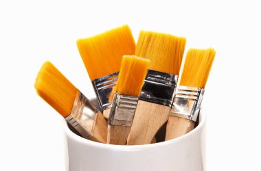 Farklı boyutlarda turuncu sentetik fırçalar dikey konumda.