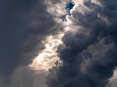 Yağmuru anons eden gölgeli ve ışıklı fırtına bulutları. Tehlike kavramı.