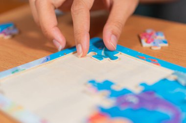 Yaşlı kadın evde yapboz yapıyor.