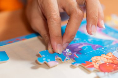 Yaşlı kadın evde yapboz yapıyor.