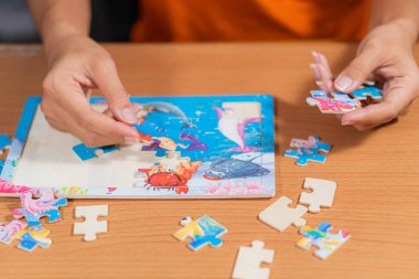 Yaşlı kadın evde yapboz yapıyor.