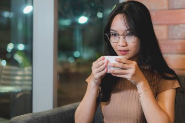 Kafede kahve içen bir kız, güzel saçları olan bir kız.