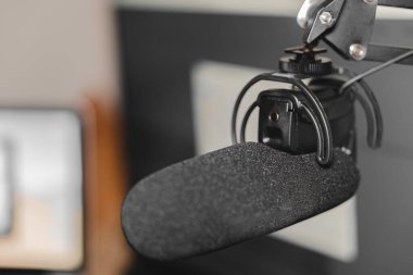 Home studio podcast interior. Microphone, laptop and on air lamp on the table, close-up