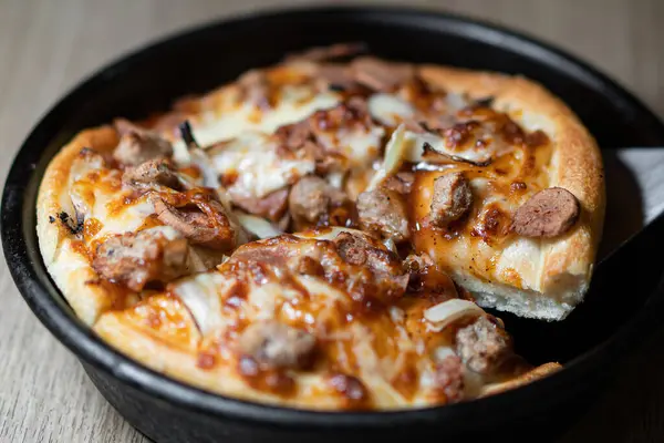 Koyu ahşap arka planda küçük bir pizza.