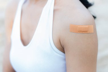 Yapışkan bandajlı bir kadın kolu