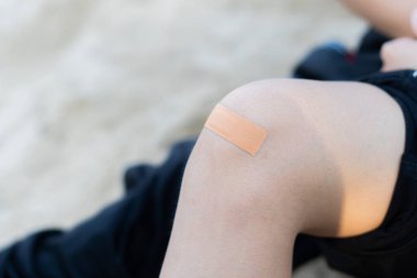 Kadın dizine sıva yapıyor.