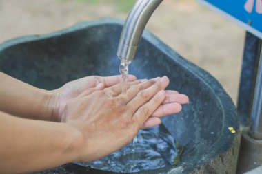 Muslukta sabun ve suyla ellerini yıkamak, hijyen kavramı.