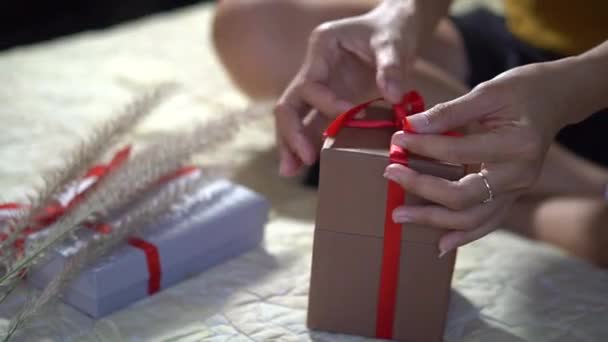 Vrouwelijke Handen Wikkelen Kerstcadeau Strikken Rood Lint — Stockvideo