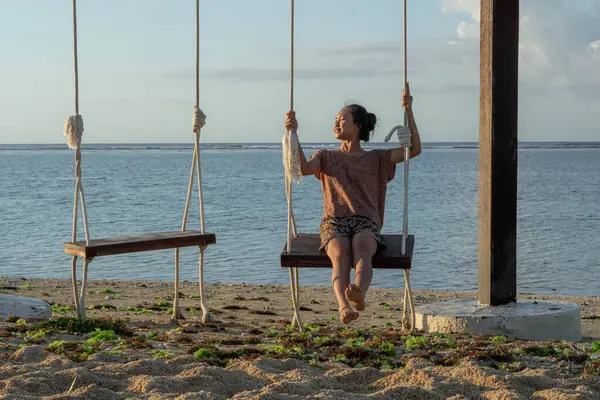 a woman with swing on her head on the seashore