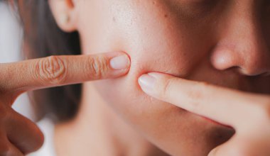 Genç bir kadın parmağına lens takıyor.